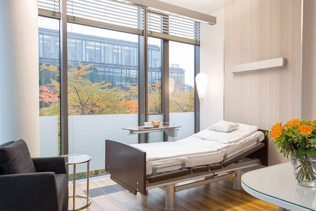 Modernes Patientenzimmer mit einem Bett und großem Fenster