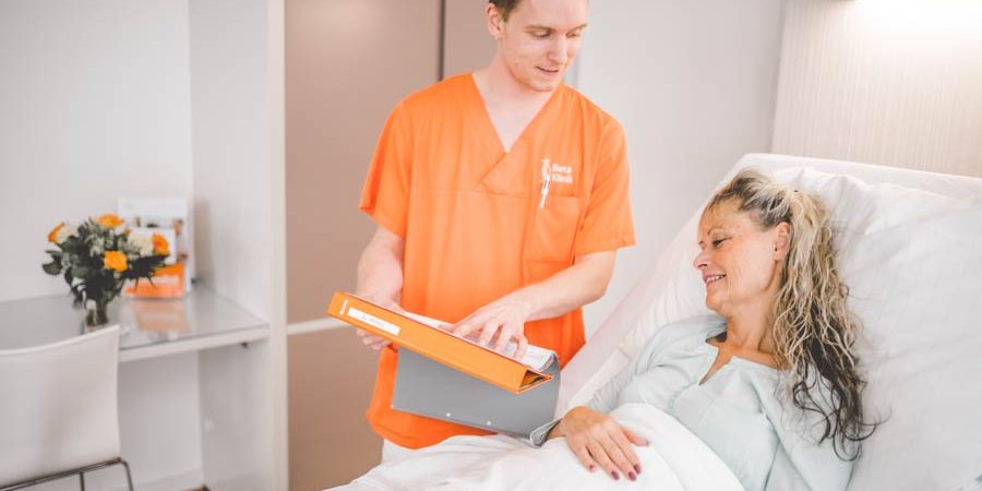 Patient mit Pfleger im Patientenzimmer in Bonn