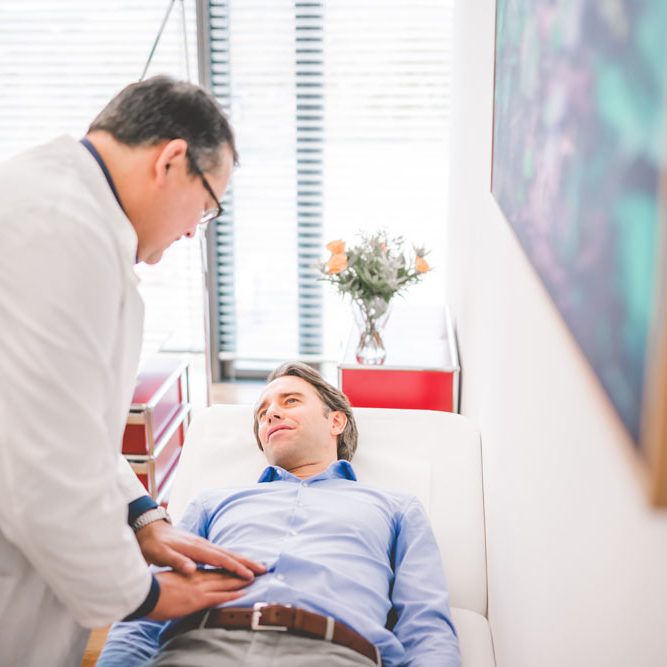 Stefan Mühlbauer fühlt Bauch bei Patienten