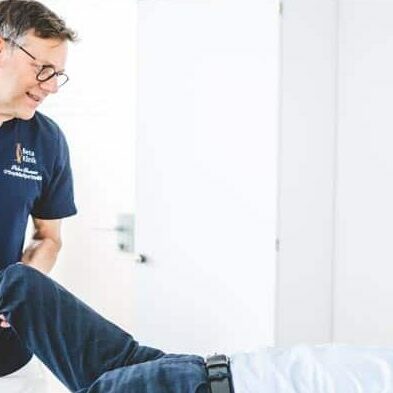 Peter Braun untersucht Patient auf Liege