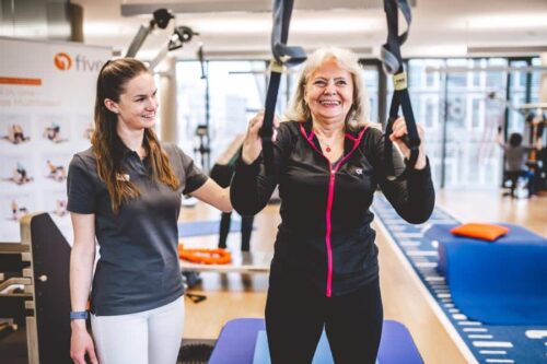 Patient trainiert an Seilen mit Physiotherapeutin