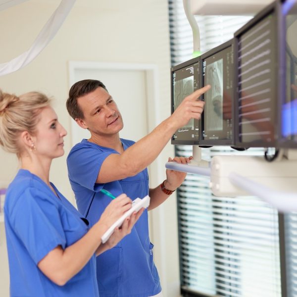 Arzt zeigt mit Finger auf Monitor