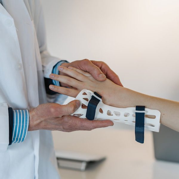 Arzt legt Patient Gelenkschiene an