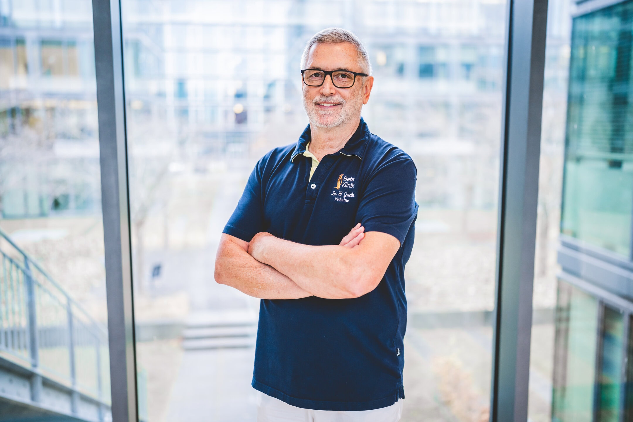 Kinderarzt Dr. med. Werner Garbe, frontal in die Kamera blickend und lächelnd.