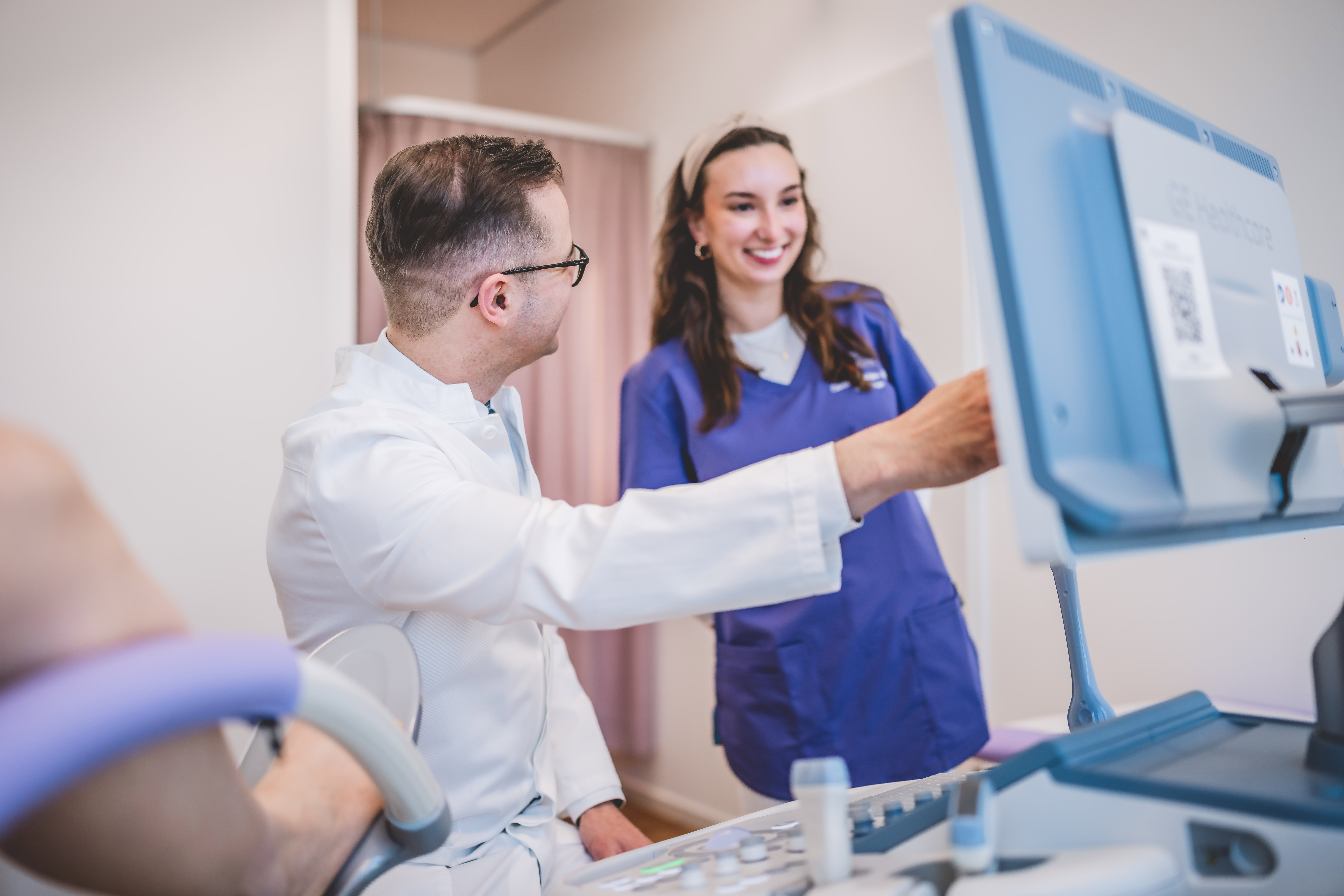 Gynäkologe Dr. Gantert zeigt Assistenzärztin etwas auf einem Bildschirm