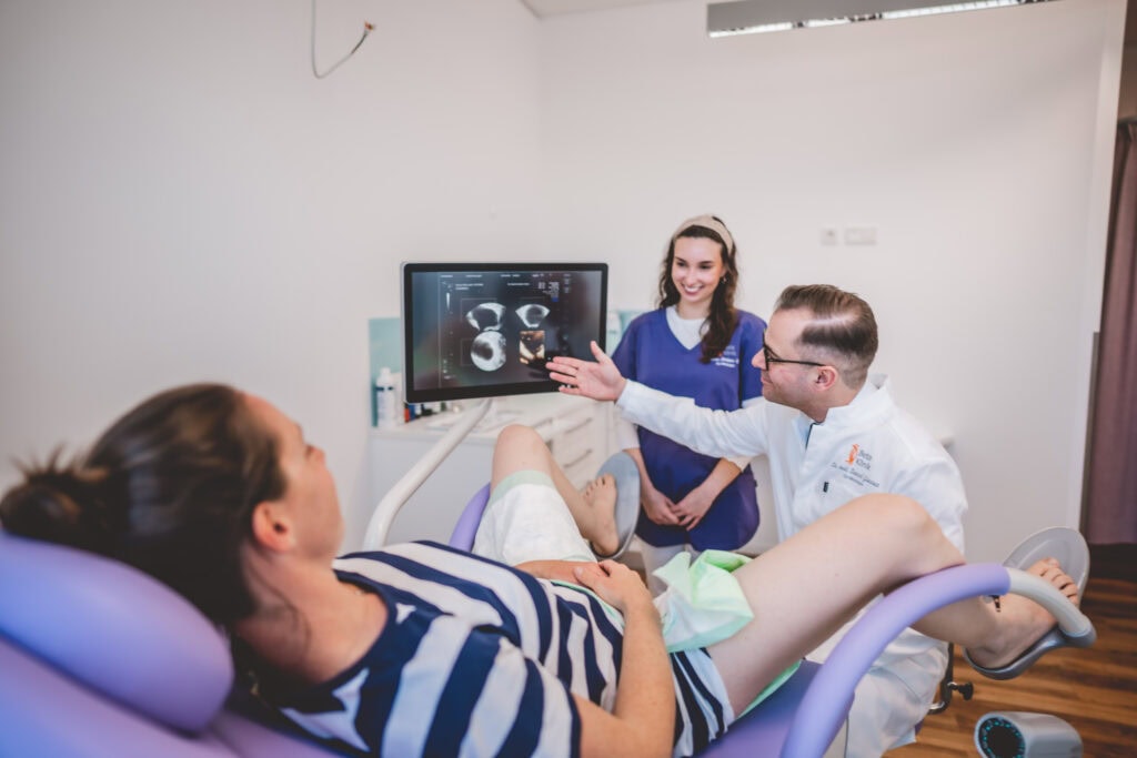 Gynäkologe Dr. Gantert an Ultraschallgerät für einen Vaginal Ultraschall einer Patientin. Zeigt Patientin Ultraschall auf einem Bildschirm