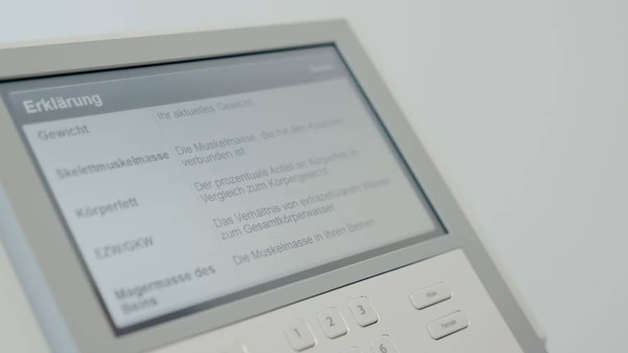 Ein Bildschirm mit Körperanalyse-Daten und darunter weiße Tasten.