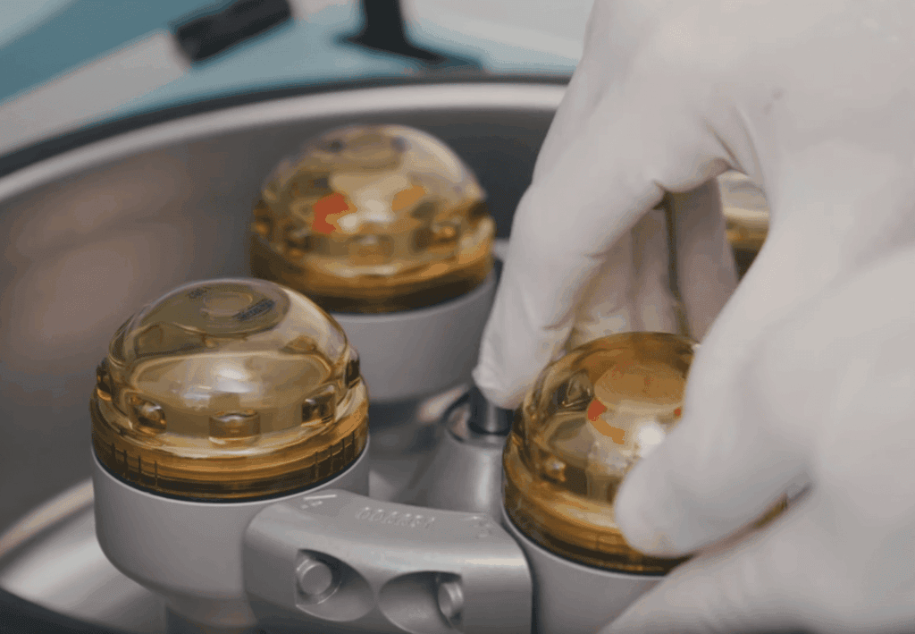 Ein Mann mit Brille lächelt in einem Büro mit unscharfem Hintergrund.