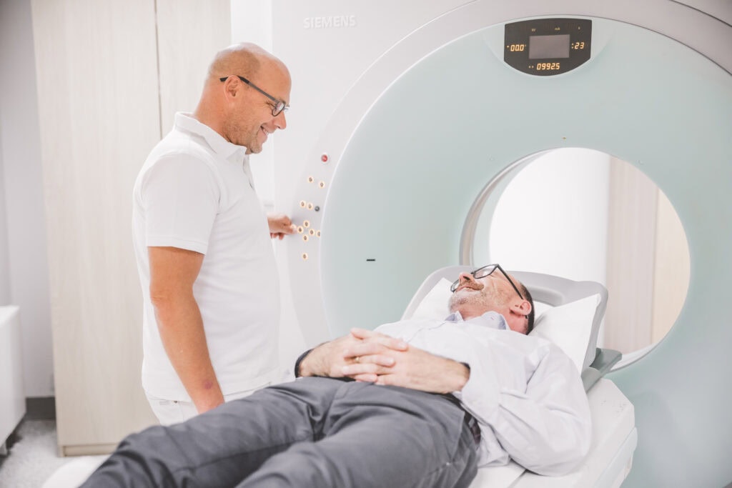 Arzt berietet Patienten auf MRT vor.