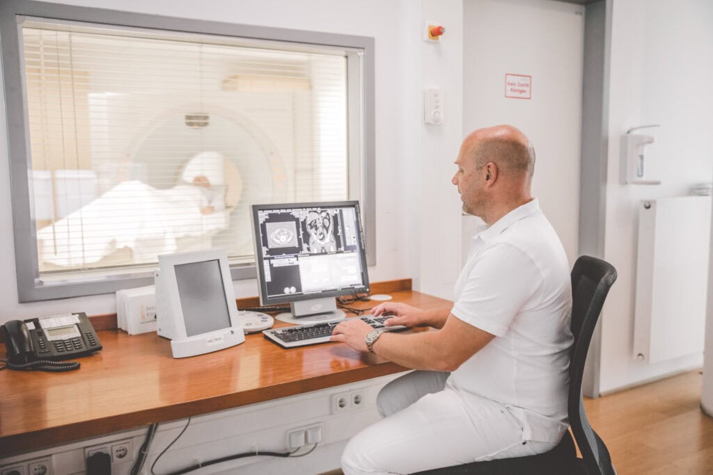 Arzt betrachtete Untersuchungsergebnisse eines MRTs am Bildschirm.