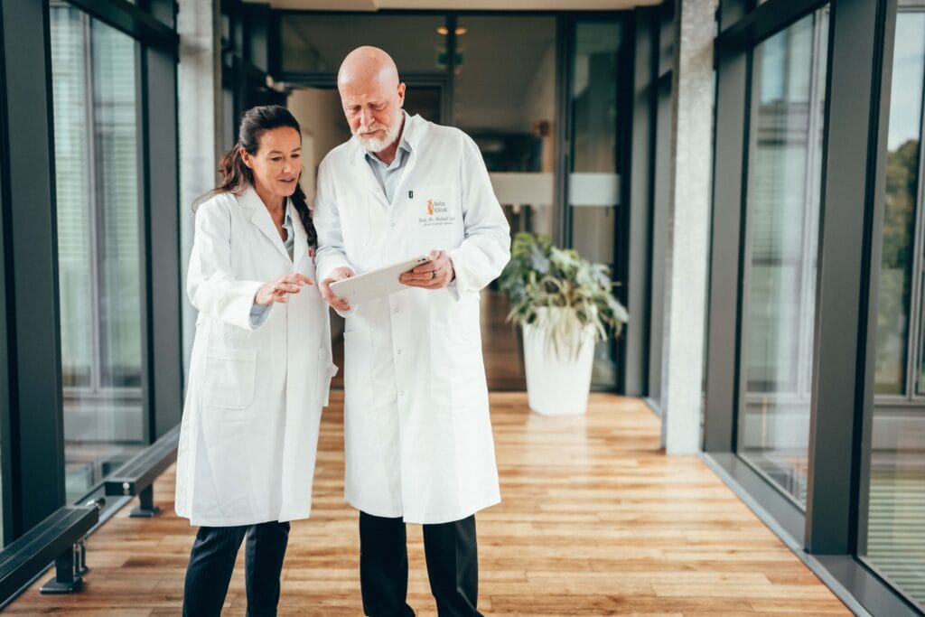 Neuroonkologen Dr. Sabel und Dr. Rapp besprechen Daten auf einem IPad.