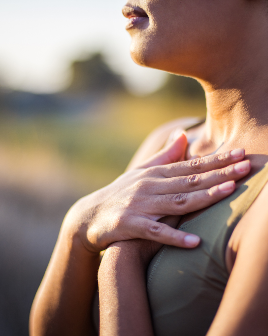 Frau_Atmung_1 Eine junge Frau hält ihre Hände auf ihre Brust und atmet ein.