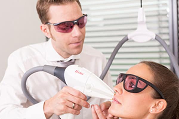 Laser Behandlung: Arzt entfernt die Gesichtshaare einer Patientin mit dem Laser