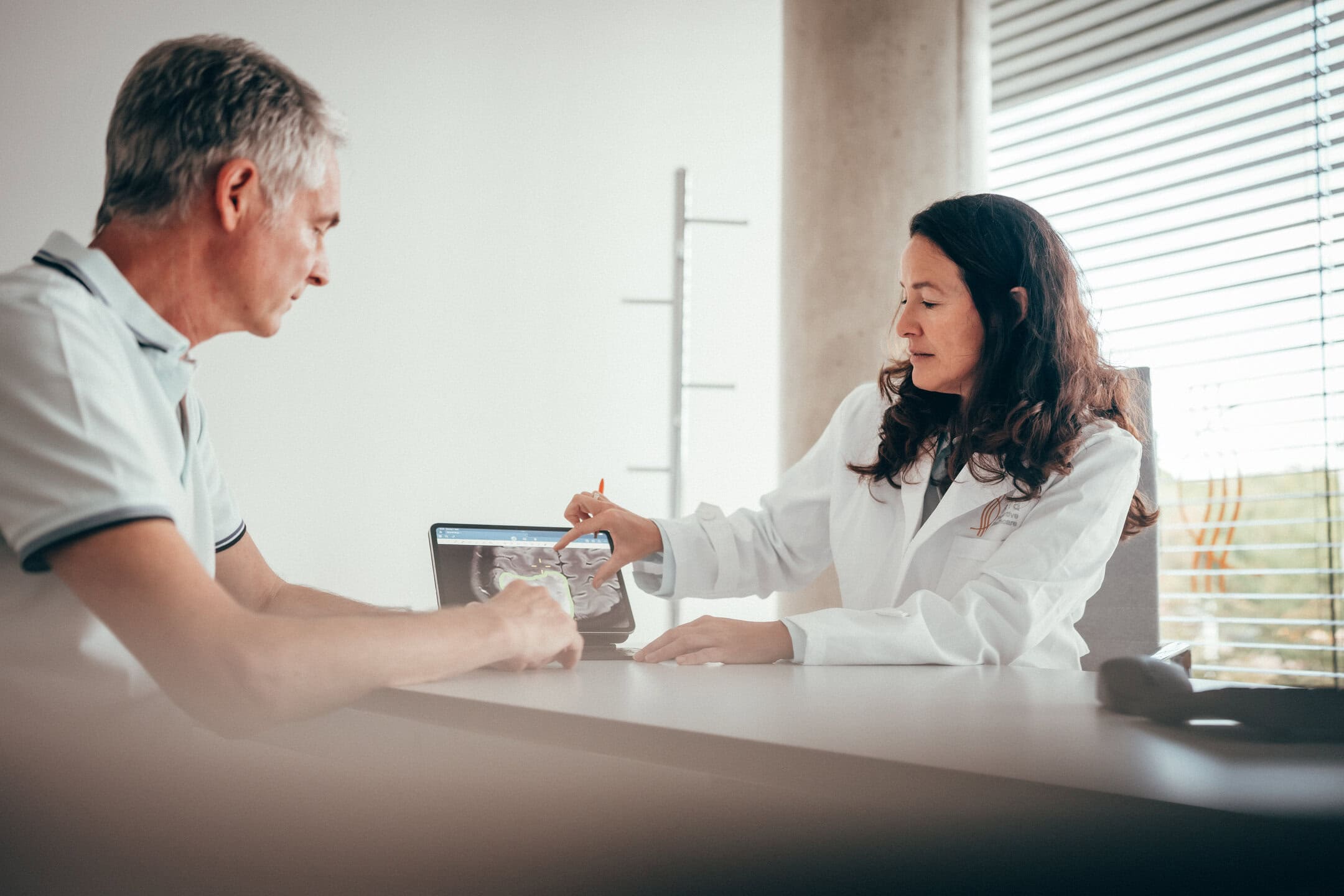 Frau Prof Rapp erläutert einem Patienten die Diagnose anhand einer MRT Untersuchung